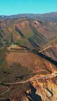 Transport moving by the bridge and highway in the mountains. California rocky shore at the Pacific coast on sunny day. Top view. Vertical video