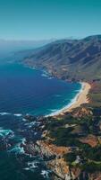 Green inhabited locality among the bare rugged mountains of California. Endless sight of the ocean with hazy horizon at backdrop. Aerial view. Vertical video