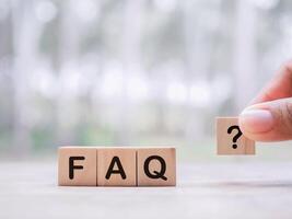 Wooden block with word the FAQ with question marks. The concept of question or answer time. photo