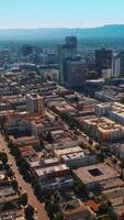 Los Angeles architecture on beautiful sunny daytime. Hazy mountains at backdrop of blue skies. Top view. Vertical video
