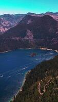 Tremendous view of beautiful Lake Tahoe surrounded by Sierra Nevada mountains. Stunning wildlife panorama at the backdrop of blue sky. Vertical video