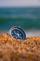 Conceptual photo of a compass in a deserted uninhabited area. Compass lying on the seashore, stability and peace