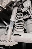 Close-up view from under the car. Dirty suspension of an off-road vehicle. Transmission components photo