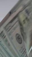 Mechanismus im Kasse Zählen Maschine drehen schnell. uns hundert Dollar Banknoten gezählt im das Geld Zählen Ausrüstung. schließen hoch. Vertikale video