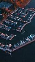 Lots of boats and yachts at the pier of Lake Tahoe. Drone footage over the lake waters with many boats sailing on. Vertical video