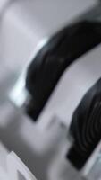 Rotating mechanism turning quickly hundred dollar US bills. Work of cash counting machine close up. Blurred background. Vertical video