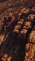 Land of rocks with no greenery and rounded mountains. Aerial view of sunny desert in Utah, USA. Vertical video