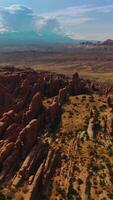 Flat rocks of beautiful canyons on sunny hot day. Huge cloudscape over the mountains at backdrop. Top view. Vertical video
