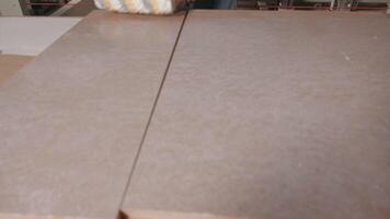 Close up of process of priming wooden board surface at the factory. Industrial background, concept of carpentry. video