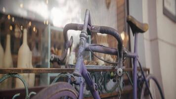 Vintage bicycle with chain at store. Action. Antique bicycle stands at window of store. Old rusty bicycle stands outside building on sunny day video