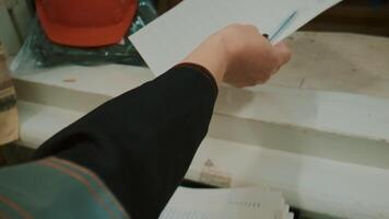 Elderly woman takes notes in laboratory. Clip. Female dispatcher in uniform writes in log. Dispatcher records data on devices in technical log video