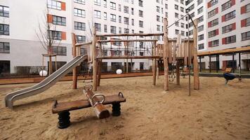 im das Hof von ein modern hoch erhebt euch Gebäude auf ein Sommer- Tag. Lager Filmaufnahme. leeren modern Kinder Spielplatz. video