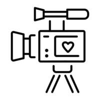 A line icon depicting a camcorder with a heart on the screen, mounted on a tripod vector