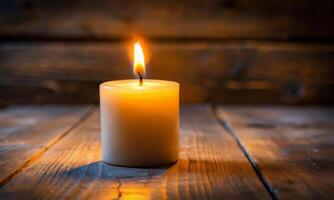 A burning wax candle on a wooden table on an abstract background photo