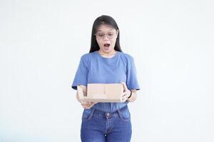 beautiful Asian woman holds a box package, displaying a shocked wow face expression against a white background photo