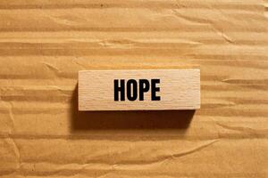 Hope message written on wooden block with cardboard background. Conceptual hope symbol. Copy space. photo