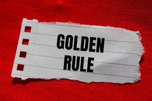 Golden rule message written on ripped torn paper piece with red background. Conceptual golden rule symbol. Copy space. photo