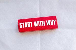 Start with why message written on red wooden block with white background. Conceptual start with why symbol. Copy space. photo