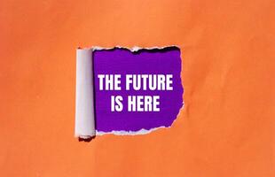 The future is here message written on ripped torn orange paper with purple background. Conceptual the future is here symbol. Copy space. photo