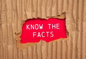 Know the facts message written on ripped torn cardboard paper with red background. Conceptual know the facts symbol. Copy space. photo