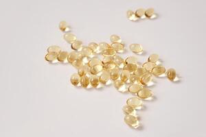 Scattered transparent capsules on white background highlighting health and wellness supplements photo