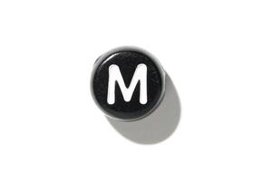 Black keyboard key with letter m isolated on white background with shadow for minimalist design concepts photo