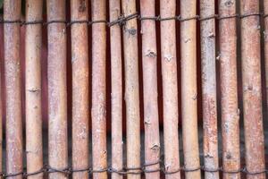 Rustic bamboo fence texture with natural wooden sticks and rough surface pattern. photo