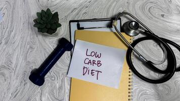 Concept of Low Carb Diet write on sticky notes isolated on Wooden Table. photo