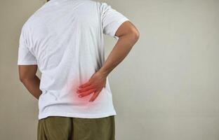 Man standing with hand touching her back having back pain photo