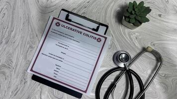 Concept of Ulcerative Colitis write on document isolated on Wooden Table. photo