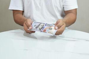 Young man with money on grey background photo
