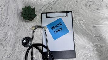 Concept of Health check write on sticky notes isolated on Wooden Table. photo
