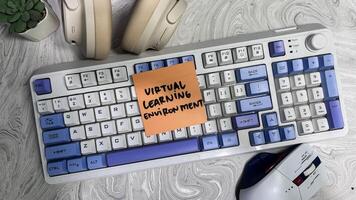 Concept of Virtual Learning Environment write on sticky notes isolated on Wooden Table. photo