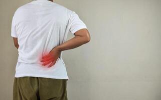 Man standing with hand touching her back having back pain photo