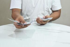 Person's hands holding and counting money in cash photo