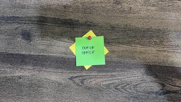 Concept of Out of Office write on sticky notes isolated on Wooden Table. photo
