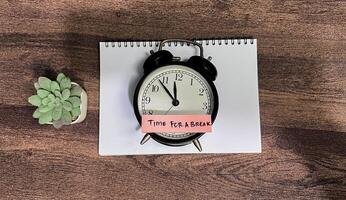 Concept of Time For a Break write on sticky notes isolated on Wooden Table. photo