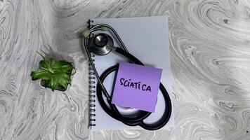 Concept of Sciatica write on sticky notes isolated on Wooden Table. photo