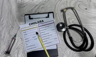 Concept of Cholera write on document isolated on Wooden Table. photo