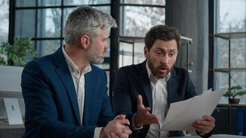 Nervous angry man boss argue scolds employee because mistake in documents financial papers Caucasian men businessmen arguing in office meeting business conflict problem mistake work failure bad result photo