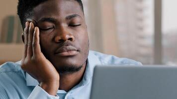Sleepy tired african man office male dreamer businessman has sleeping problem napping rest at desk american lazy student overworked guy in retire closed eyes feeling exhausted after hard computer work photo