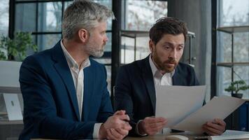 Nervous angry man boss argue scolds employee because mistake in documents financial papers Caucasian men businessmen arguing in office meeting business conflict problem mistake work failure bad result photo