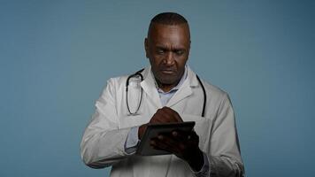 African American man professional doctor therapist consultant consulting patient using digital tablet for online appointment modern treatment read data analysis results use virtual medical application photo