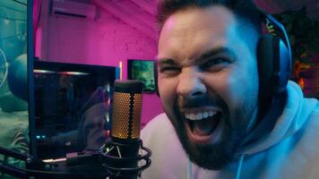 Surprised Caucasian man guy addict gamer shock male influencer playing game online using pc gaming focused blogger player streaming record blog cyber sport e-sport smiling streamer laugh at home photo