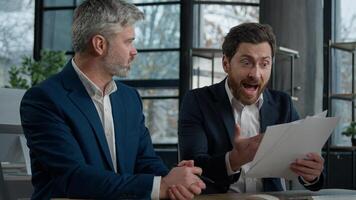 Nervous angry man boss argue scolds employee because mistake in documents financial papers Caucasian men businessmen arguing in office meeting business conflict problem mistake work failure bad result photo