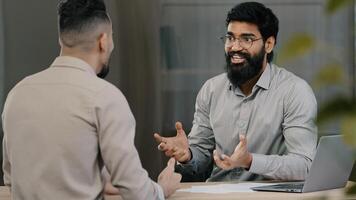 Two multiracial arabic hispanic colleagues businesspeople men discuss startup accept common project satisfied with result of negotiation give high five agreement partnership teamwork at office meeting photo