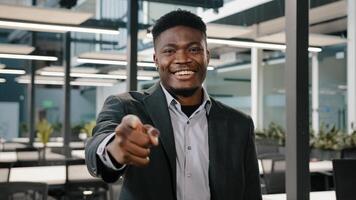 multirracial hombre americano masculino empresario inversor financiero especialista de grande empresa en pie con sonrisa señalando índice dedo a cámara con Oye usted gestos elegir haciendo elección en oficina salón foto