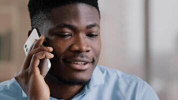 African american happy businessman guy talk on cellphone gadget communicate friendly with partner professional young male investor hold modern device smiling discuss information remote share good news photo