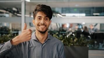 Happy hispanic employee arab man leader winner approve looking at camera showing thumb up agreement sign everything fine success gesture body language in office recommend good choice close-up portrait photo