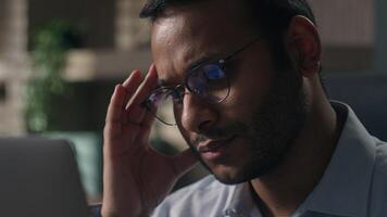 Close up pensive thoughtful male office worker reading bad news in laptop think concerned Indian man American businessman thinking problem solution worry anxiety difficulties business data failure photo